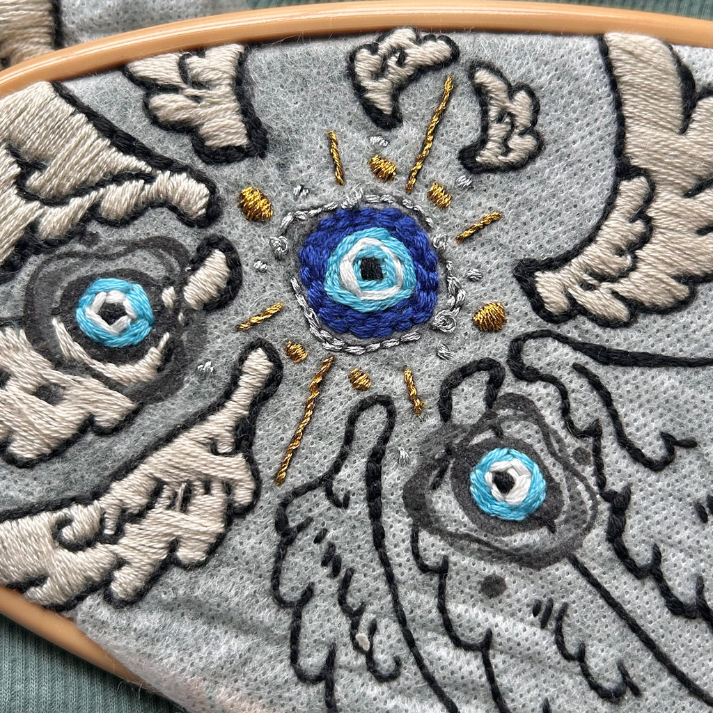 A hooped evil eye with wings