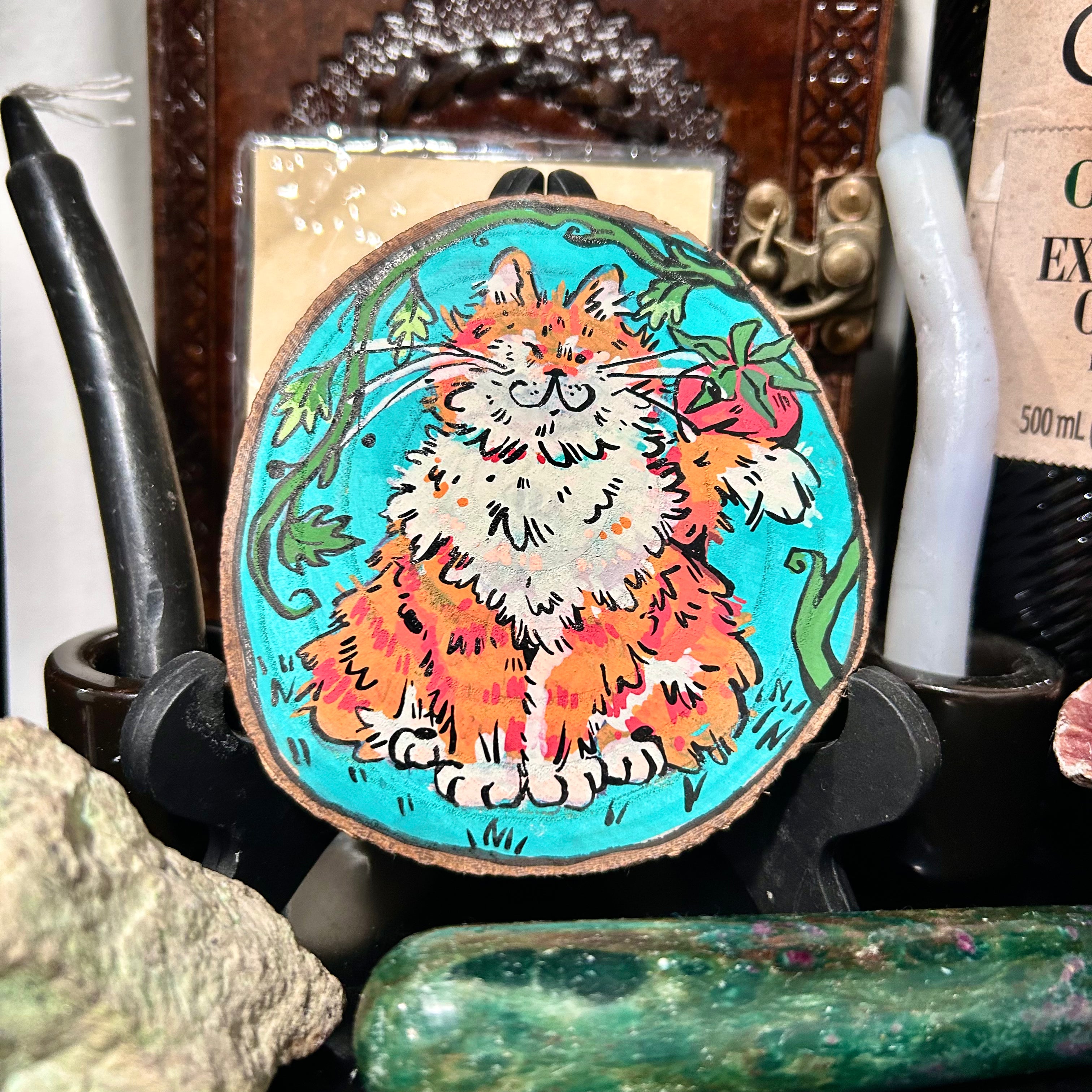 colorful acrylic painting of a fully orange tabby holding a tomato decorative coaster
